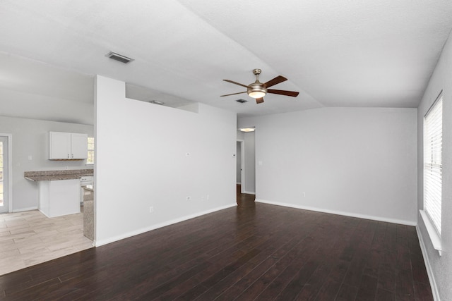 empty room with ceiling fan, vaulted ceiling, and light hardwood / wood-style floors