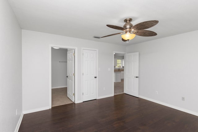 unfurnished bedroom featuring dark wood-type flooring and ceiling fan