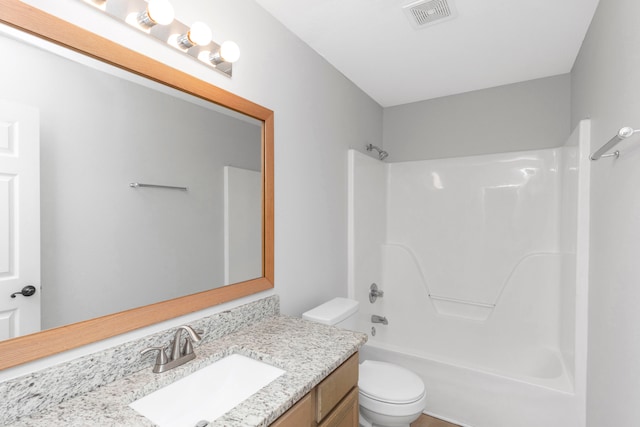 full bathroom with toilet, vanity, and shower / washtub combination