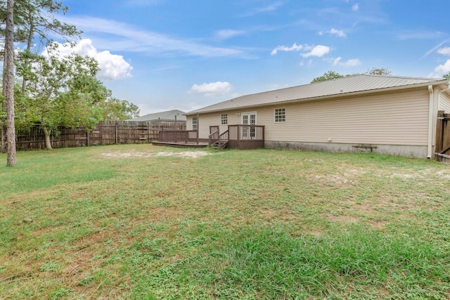 back of property featuring a wooden deck and a yard