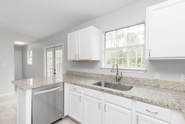 kitchen featuring kitchen peninsula, plenty of natural light, sink, stainless steel dishwasher, and white cabinetry