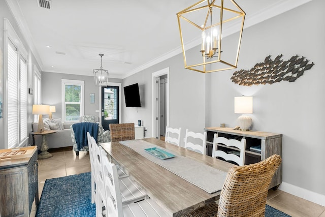 tiled dining area featuring an inviting chandelier and crown molding