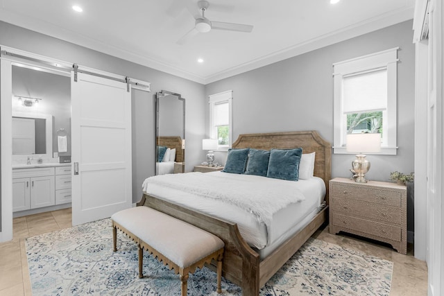 bedroom with ensuite bath, a barn door, light tile patterned floors, sink, and ceiling fan