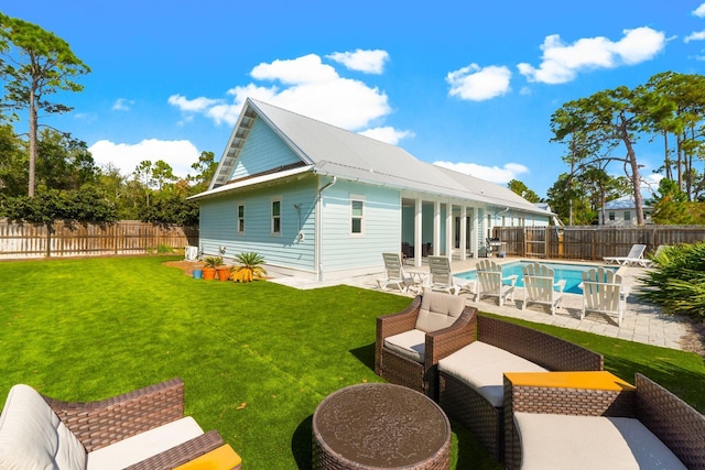 back of house featuring a lawn, a patio, and a fenced in pool