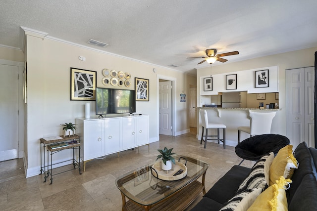 living room with ceiling fan, a textured ceiling, and ornamental molding