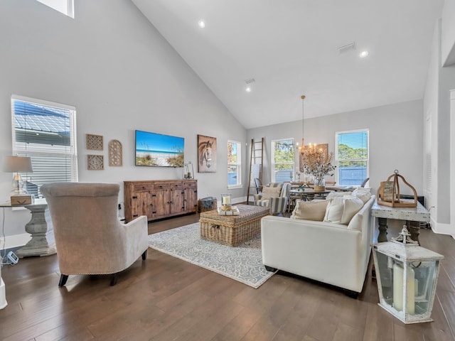 living room featuring high vaulted ceiling, dark hardwood / wood-style flooring, and an inviting chandelier