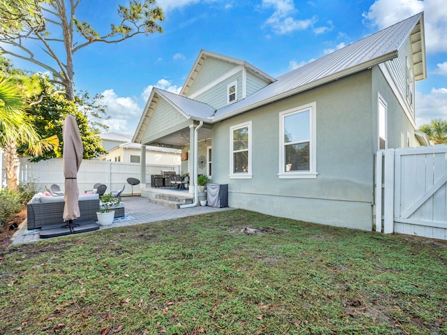 back of property featuring outdoor lounge area, a lawn, and a patio area