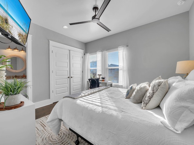 bedroom with a closet, hardwood / wood-style flooring, and ceiling fan