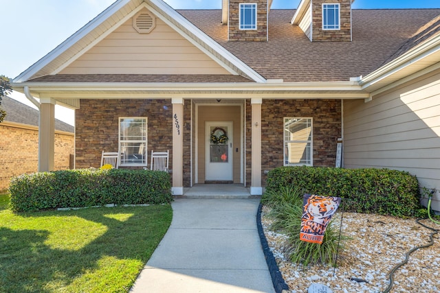 property entrance with a porch and a lawn