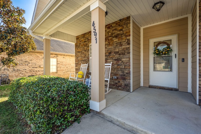 view of exterior entry featuring covered porch