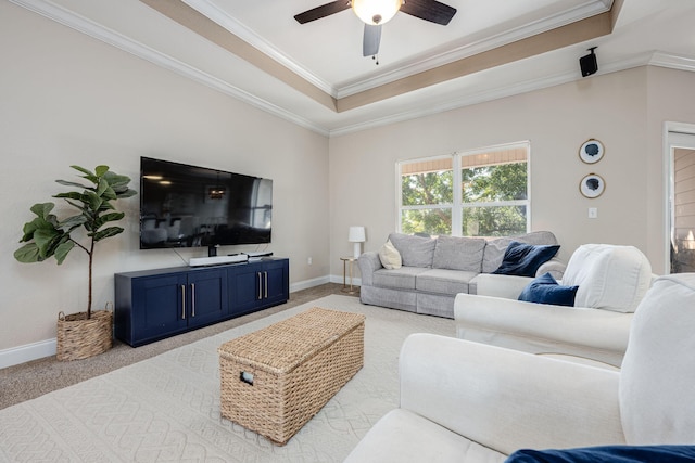 carpeted living room featuring a raised ceiling, ceiling fan, and crown molding