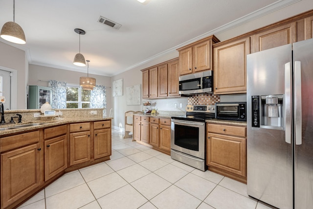 kitchen with ornamental molding, stainless steel appliances, light stone countertops, hanging light fixtures, and sink