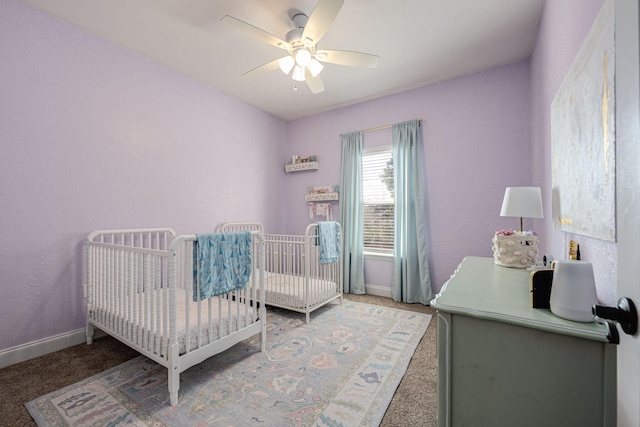 carpeted bedroom featuring a crib and ceiling fan