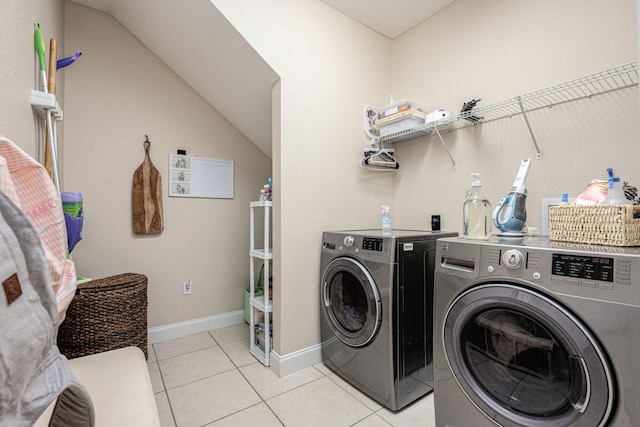 laundry room with light tile patterned flooring and washer and clothes dryer