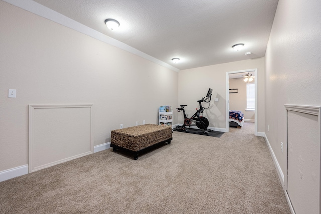 workout room with light colored carpet and ceiling fan