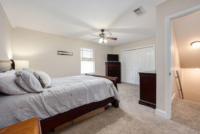 carpeted bedroom featuring a closet, lofted ceiling, and ceiling fan