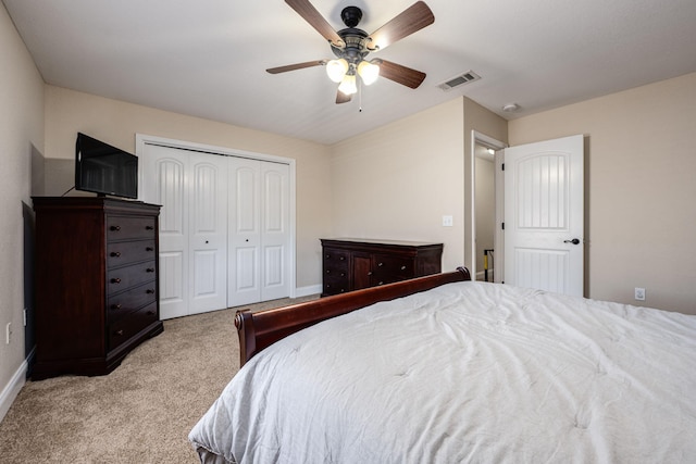 bedroom with a closet, light carpet, and ceiling fan