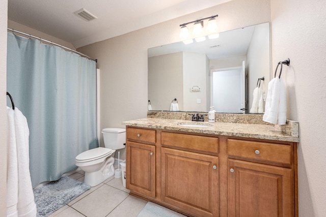 bathroom featuring toilet, vanity, and tile patterned floors