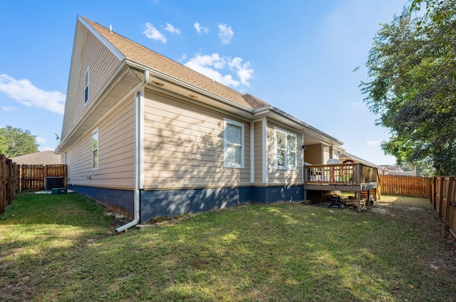 back of property featuring a lawn and a wooden deck