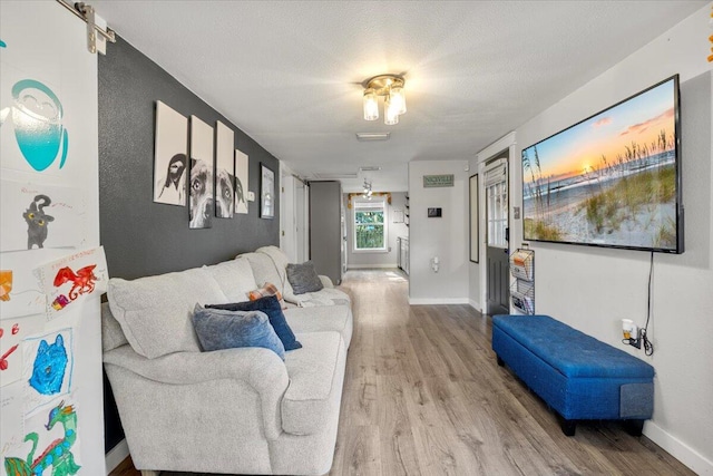 living room with light hardwood / wood-style floors and a textured ceiling