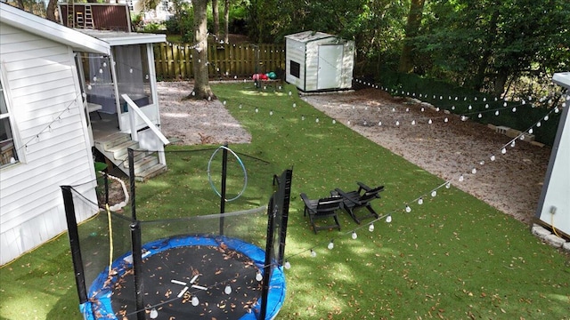 view of yard with a trampoline and a storage unit