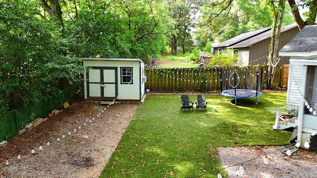 view of yard with a trampoline and a storage shed