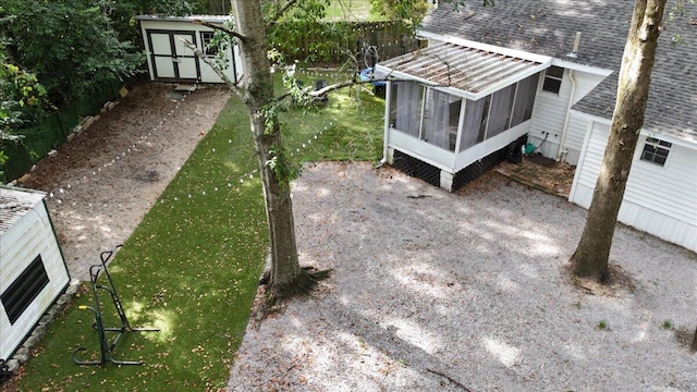 view of yard featuring a storage unit and a sunroom