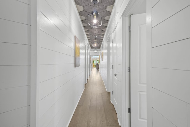 hallway with wood walls and hardwood / wood-style floors