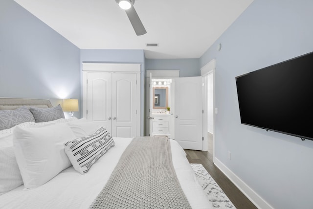 bedroom featuring dark wood-type flooring, a closet, ceiling fan, and ensuite bath