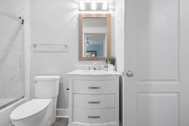 full bathroom featuring shower / bath combination with glass door, vanity, and toilet