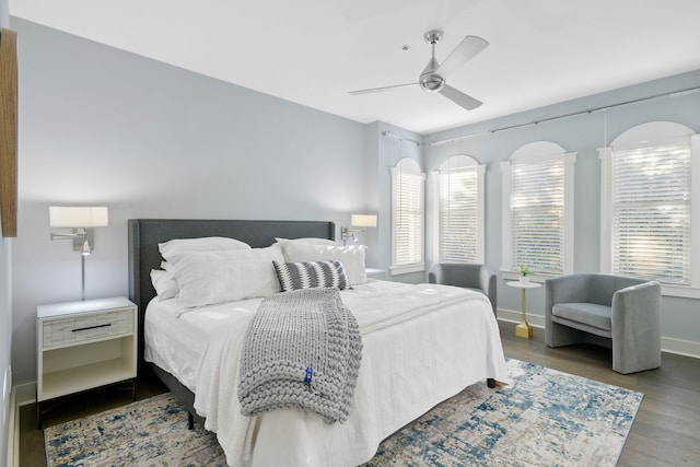 bedroom with multiple windows, hardwood / wood-style flooring, and ceiling fan