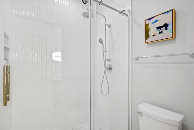 bathroom featuring toilet and an enclosed shower