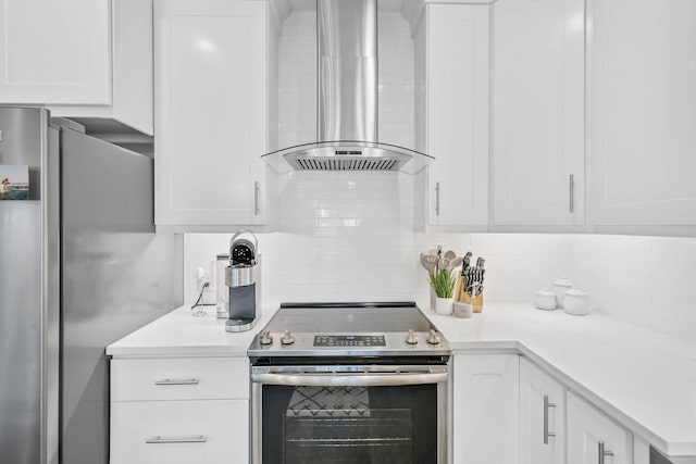 kitchen with white cabinets, stainless steel appliances, wall chimney exhaust hood, and backsplash