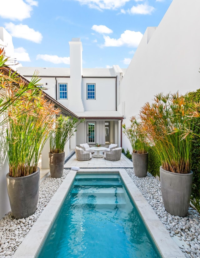 45 N Charles St, Inlet Beach, FL 32461 - rear view of property featuring stucco siding, an outdoor pool, a chimney, and a patio area