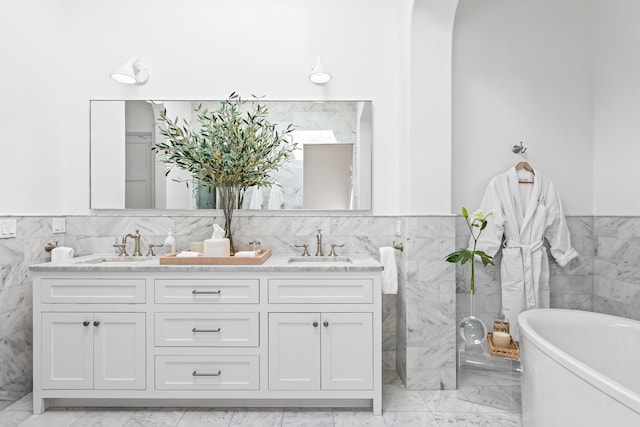 45 N Charles St, Inlet Beach, FL 32461 - bathroom with tile walls, marble look tiles, a soaking tub, wainscoting, and double vanity