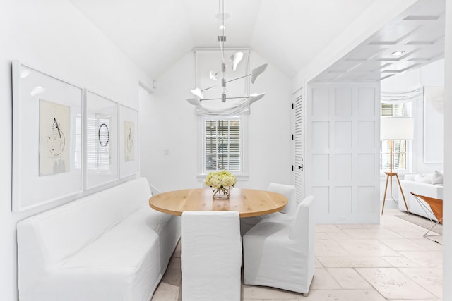 dining room with lofted ceiling and an inviting chandelier