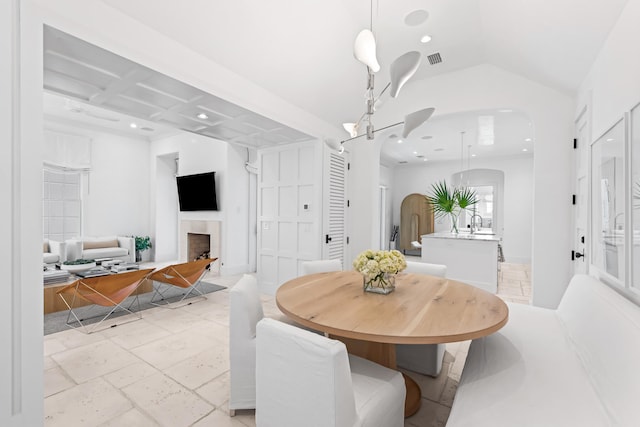 dining space with sink and coffered ceiling