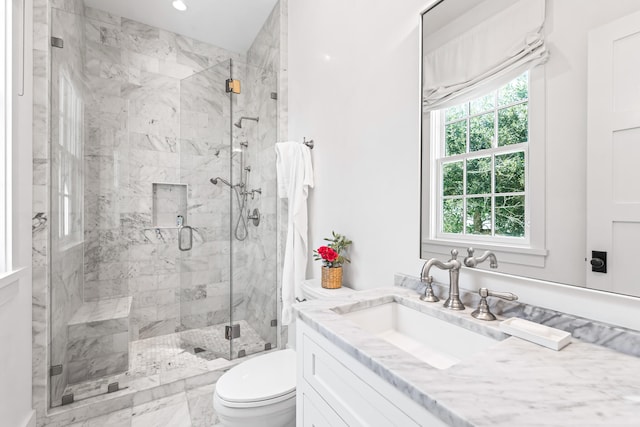 bathroom with walk in shower, vanity, and toilet