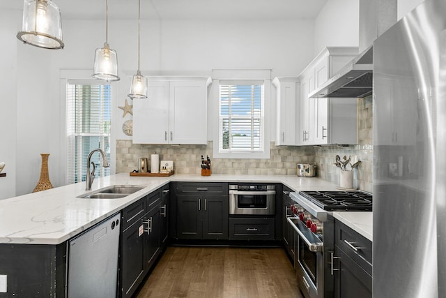 kitchen featuring dark hardwood / wood-style flooring, stainless steel appliances, sink, decorative light fixtures, and white cabinetry