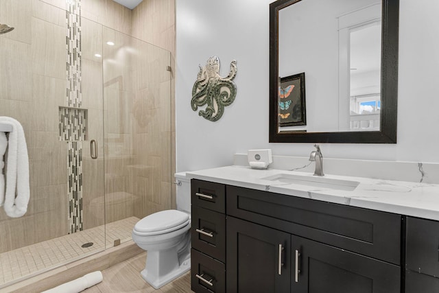 bathroom with tile patterned floors, vanity, toilet, and a shower with door