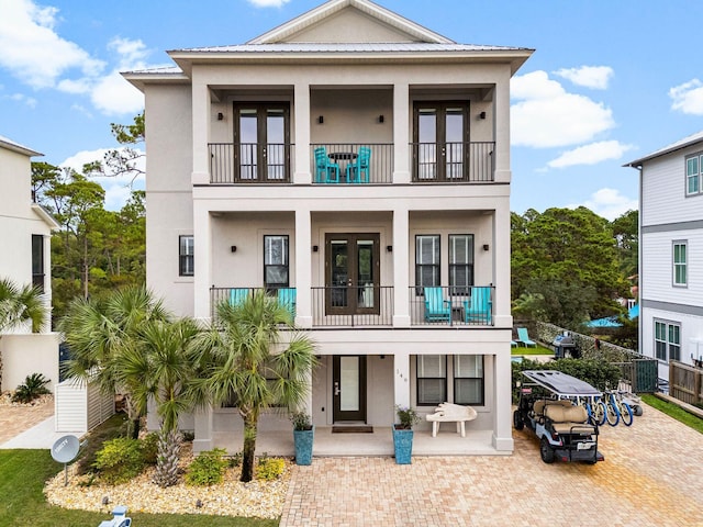 view of front of home with french doors and a balcony