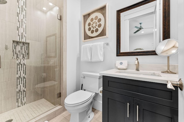 bathroom featuring ceiling fan, wood-type flooring, an enclosed shower, toilet, and vanity