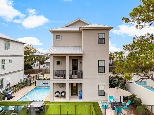 rear view of house featuring a patio and a fenced in pool