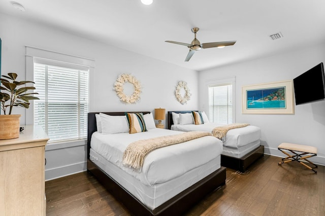 bedroom with multiple windows, ceiling fan, and dark hardwood / wood-style floors