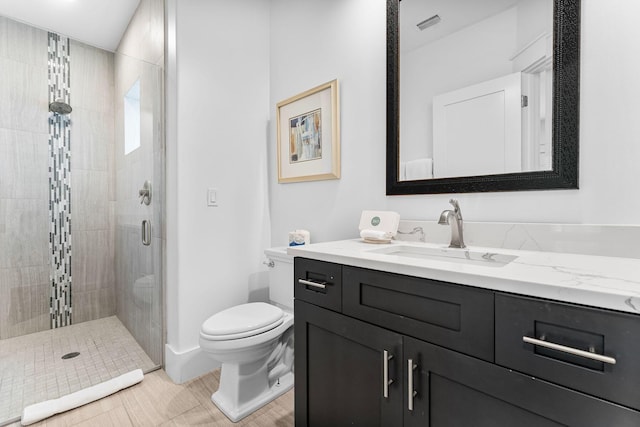 bathroom featuring tile patterned floors, vanity, toilet, and walk in shower