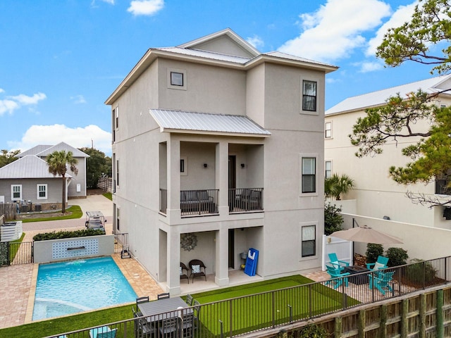 back of house featuring a fenced in pool and a patio area