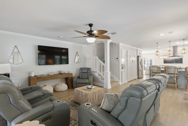 living room featuring ceiling fan, light hardwood / wood-style flooring, and crown molding