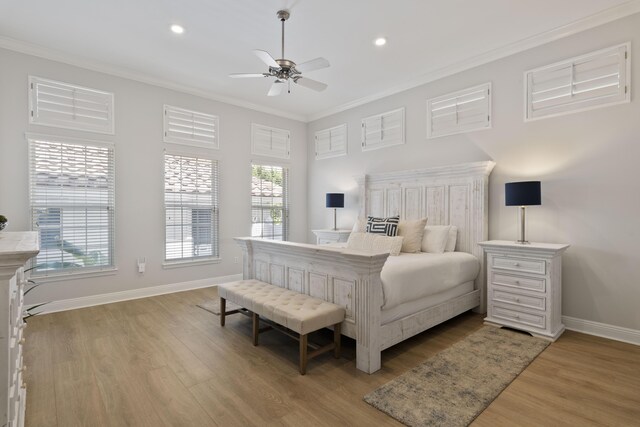 bedroom with ceiling fan, crown molding, light hardwood / wood-style flooring, and multiple windows