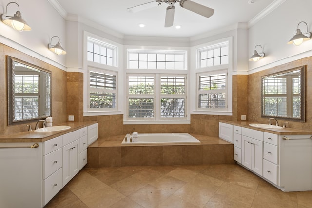 bathroom with ceiling fan, a relaxing tiled tub, vanity, and ornamental molding