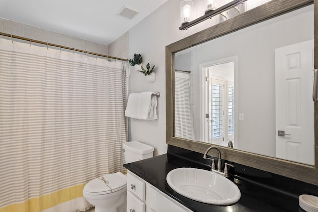 bathroom featuring toilet, vanity, and a shower with curtain